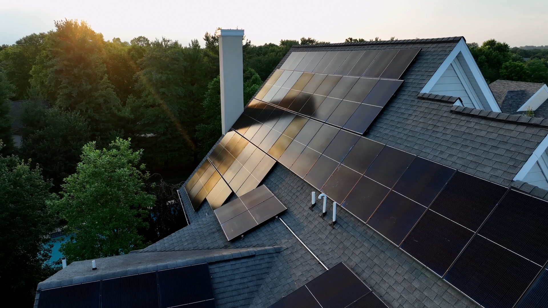Großflächige Solaranlage auf dem Dach eines Einfamilienhauses, aufgenommen bei warmem Sonnenlicht am Abend.