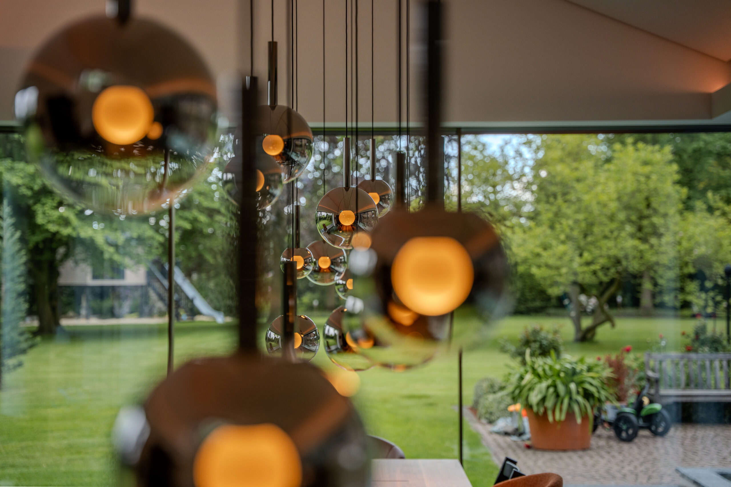 ochwertige Pendelleuchten mit Glaskugeln im modernen Wohnzimmer mit Gartenblick – Innenbeleuchtung installiert von Elektro Mersmann aus Harsewinkel
